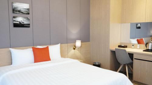 a hotel room with a bed and a kitchen at Hotel bridge Seogwipo in Seogwipo