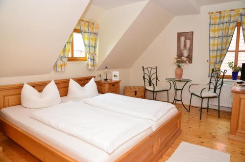 a bedroom with a bed and a table and chairs at Landhotel Gemeindeschänke in Wanfried