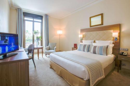 a hotel room with a large bed and a television at Westminster Hotel & Spa Nice in Nice