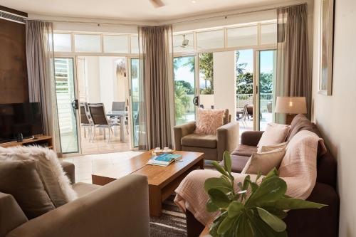 a living room with a couch and a table at Sea Change Beachfront Apartments in Trinity Beach