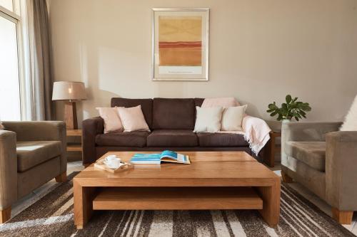 a living room with a couch and a coffee table at Sea Change Beachfront Apartments in Trinity Beach