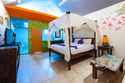 a bedroom with a bed with a canopy at Pancala Vacation Inn in Nanwan