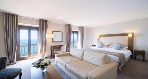 a hotel room with a bed and a couch at Westminster Hotel & Spa Nice in Nice