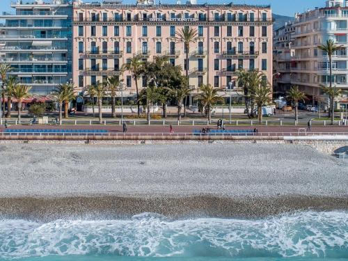 a body of water with buildings in the background at Westminster Hotel & Spa Nice in Nice