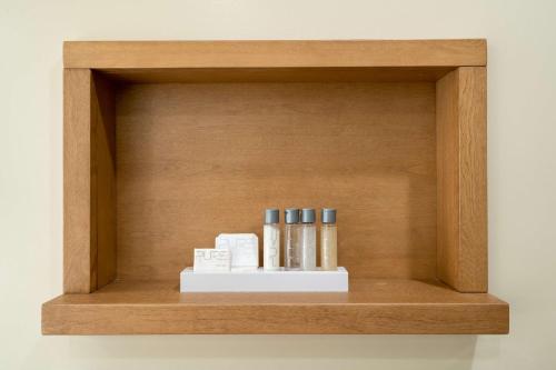 a wooden shelf with a group of books on it at The Agrarian Hotel; Best Western Signature Collection in Arroyo Grande