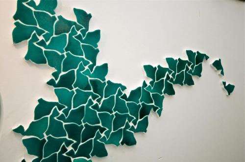 a green metal wall decoration on a white wall at Villa Casale Ravello Residence in Ravello