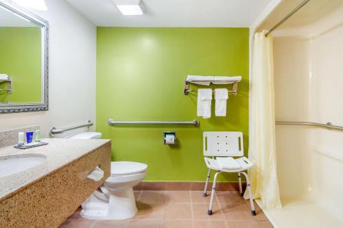 a bathroom with a toilet and a green wall at Sleep Inn Macon I-75 in Macon