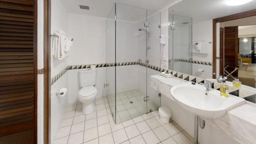 a bathroom with a sink and a toilet and a shower at Silkari The Pavilions in Port Douglas