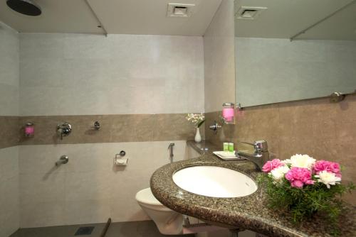 a bathroom with a sink and a toilet and a mirror at Nanutel Margao in Madgaon