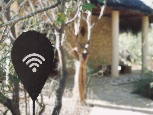 a black sign with a wifi symbol in front of a house at Auberge de la Table in Toliara