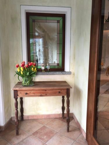 a vase of flowers on a table with a mirror at Garni Viggiona in Trarego