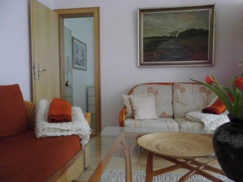 a living room with a couch and a table at SchlossparkFerienwohnungen Rheinsberg mit Garten in Rheinsberg