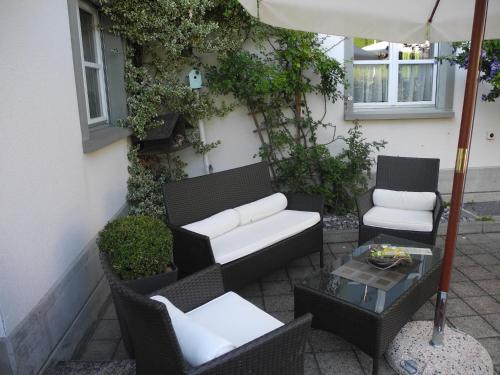 a patio with chairs and a table and an umbrella at Landgasthaus Bären in Grub