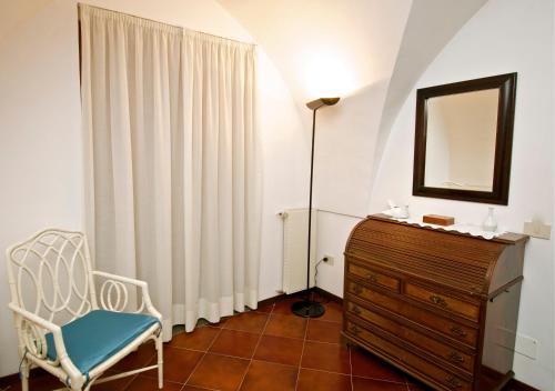 a room with a chair and a dresser and a mirror at Villa Casale Ravello Residence in Ravello