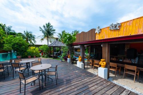 a wooden deck with tables and chairs on a restaurant at Pancala Vacation Inn in Nanwan