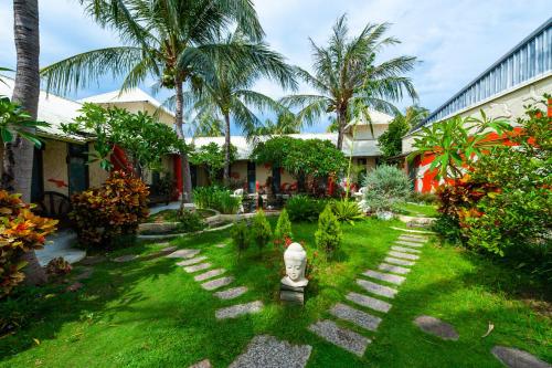 a garden with palm trees and a stone path at Pancala Vacation Inn in Nanwan