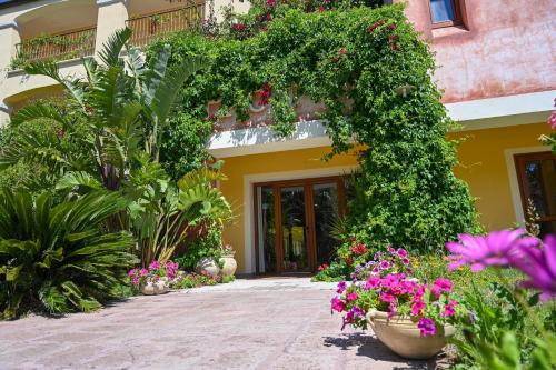 a building with a bunch of flowers and plants at Hotel Baja Romantica in Bosa