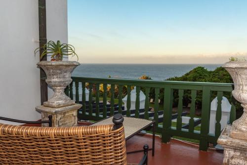 a balcony with a table and a view of the ocean at Botha House in Pennington