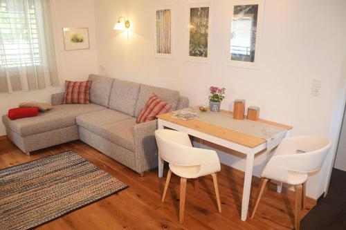 a living room with a couch and a table and chairs at Apartment Zimat in Chienes