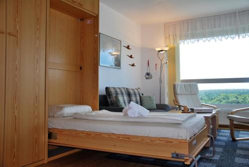 ein Schlafzimmer mit einem Bett, einem Stuhl und einem Fenster in der Unterkunft Frische Brise 12.02. in Cuxhaven