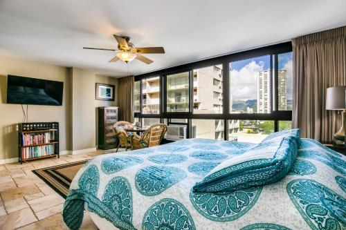 a bedroom with a bed and a large window at @ Marbella Lane Mountain View Studio, steps from Wakiki Beach in Honolulu
