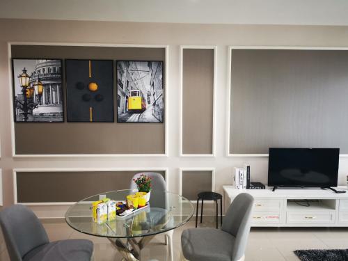 a living room with a glass table and chairs at Host Assist Homestay by HA i-City in Shah Alam