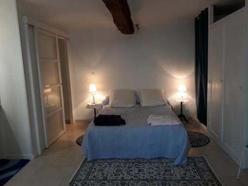 - une chambre avec un lit, deux lampes et un tapis dans l'établissement Sur les Bords de l'Indrois - Montrésor - Zoo Beauval, à Chemillé-sur-Indrois