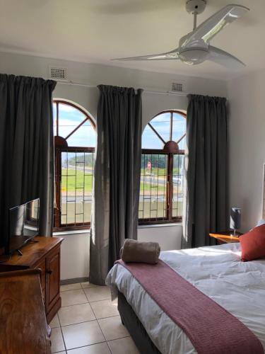 a bedroom with a bed and a tv and two windows at Sand Castle 2 in Margate