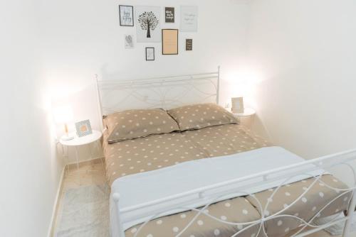 a white bed in a bedroom with two pillows at LCT Charming Beach House in Hvar