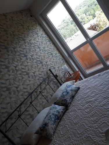 a bedroom with a bed and a large window at ACERO ROSSO in Pianfei
