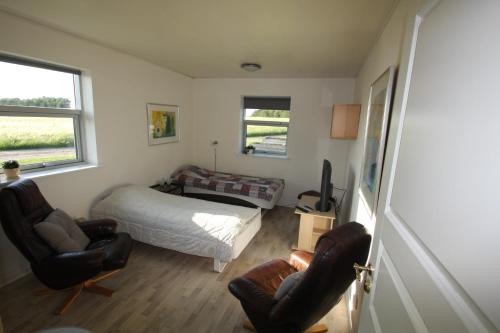 a bedroom with a bed and two chairs at Hellerup Bed & Breakfast in Løgstrup