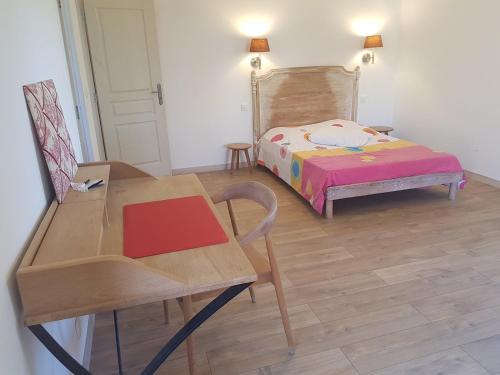 a bedroom with a bed and a table and a chair at Mas des Ballats in Saint-Bauzille-de-Putois