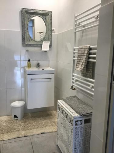 Un baño blanco con lavabo y espejo. en Le Domaine, en Lignac