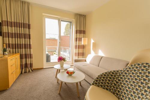 a living room with a couch and a table at Hotel Kleines Meer in Waren