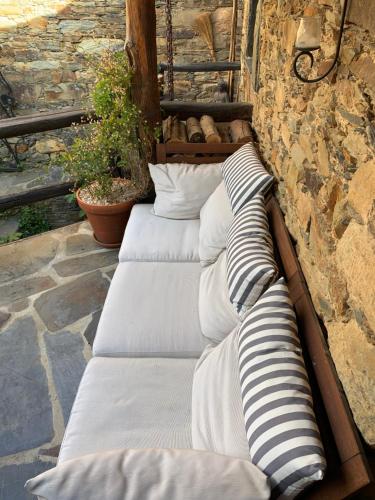 a group of pillows lined up against a stone wall at Portugal Mountain Splendour - Xisto village in Tarrastal