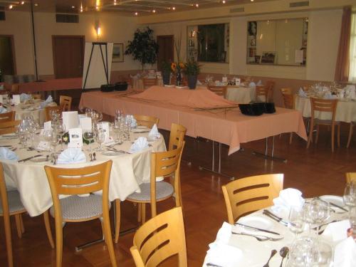 a banquet hall with tables and chairs with white table settings at Landgasthaus Bären in Grub