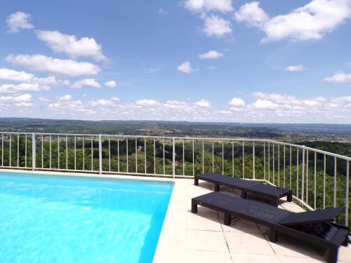 - une piscine avec 2 bancs à côté d'un balcon dans l'établissement La maison du rocher, à Carennac