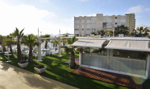 an aerial view of a hotel with palm trees and a building at Hotel & Spa Entremares in La Manga del Mar Menor