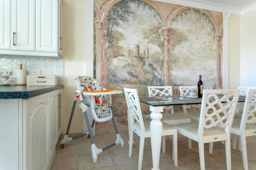 a kitchen with a table and chairs and a painting at Kings Apartment with private Garden in Paphos City