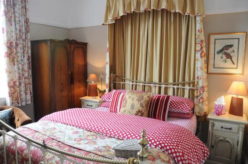 a bedroom with a bed with a red and white blanket at The Forester and Flower in Bath