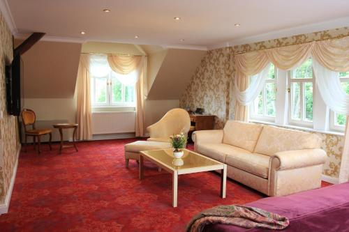 a living room with a couch and a table at Boutiquehotel Schloßpalais in Wernigerode