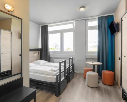 a small room with a bed and a mirror at a&o Frankfurt Galluswarte in Frankfurt/Main