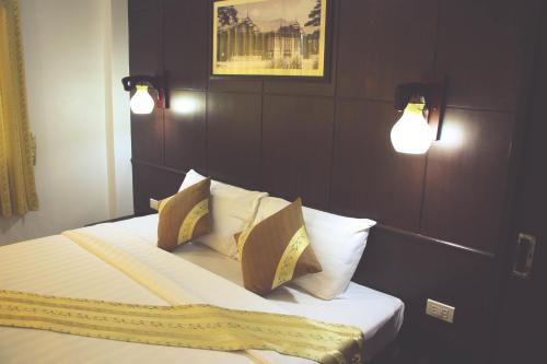 a bedroom with a bed with two lights on it at Iyara Hua Hin Lodge in Hua Hin