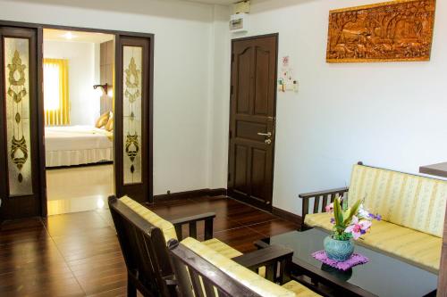 a living room with a table and a room with a bed at Iyara Hua Hin Lodge in Hua Hin