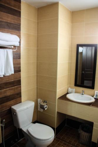 a bathroom with a toilet and a sink at Iyara Hua Hin Lodge in Hua Hin