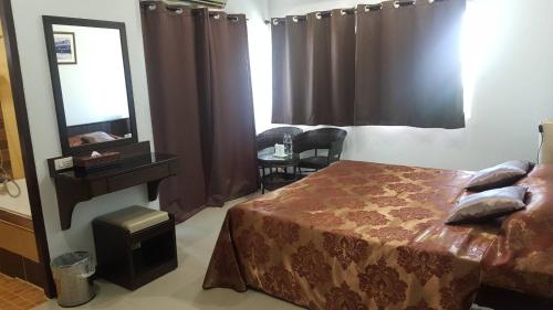 a hotel room with a bed and a mirror at Iyara Hua Hin Lodge in Hua Hin