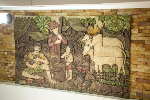 a wall mural of a family with a cow at Iyara Hua Hin Lodge in Hua Hin