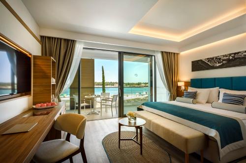 a hotel room with a bed and a view of the ocean at Marea Suites, Valamar Collection in Poreč