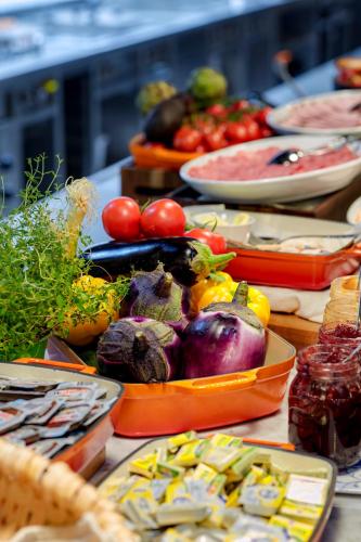 a table topped with plates of vegetables and other foods at Max Brown Hotel 7th District, part of Sircle Collection in Vienna