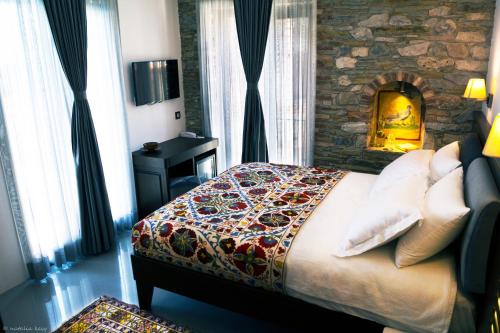 a bedroom with a bed and a stone wall at Ayasoluk Hotel & Restaurant in Selcuk